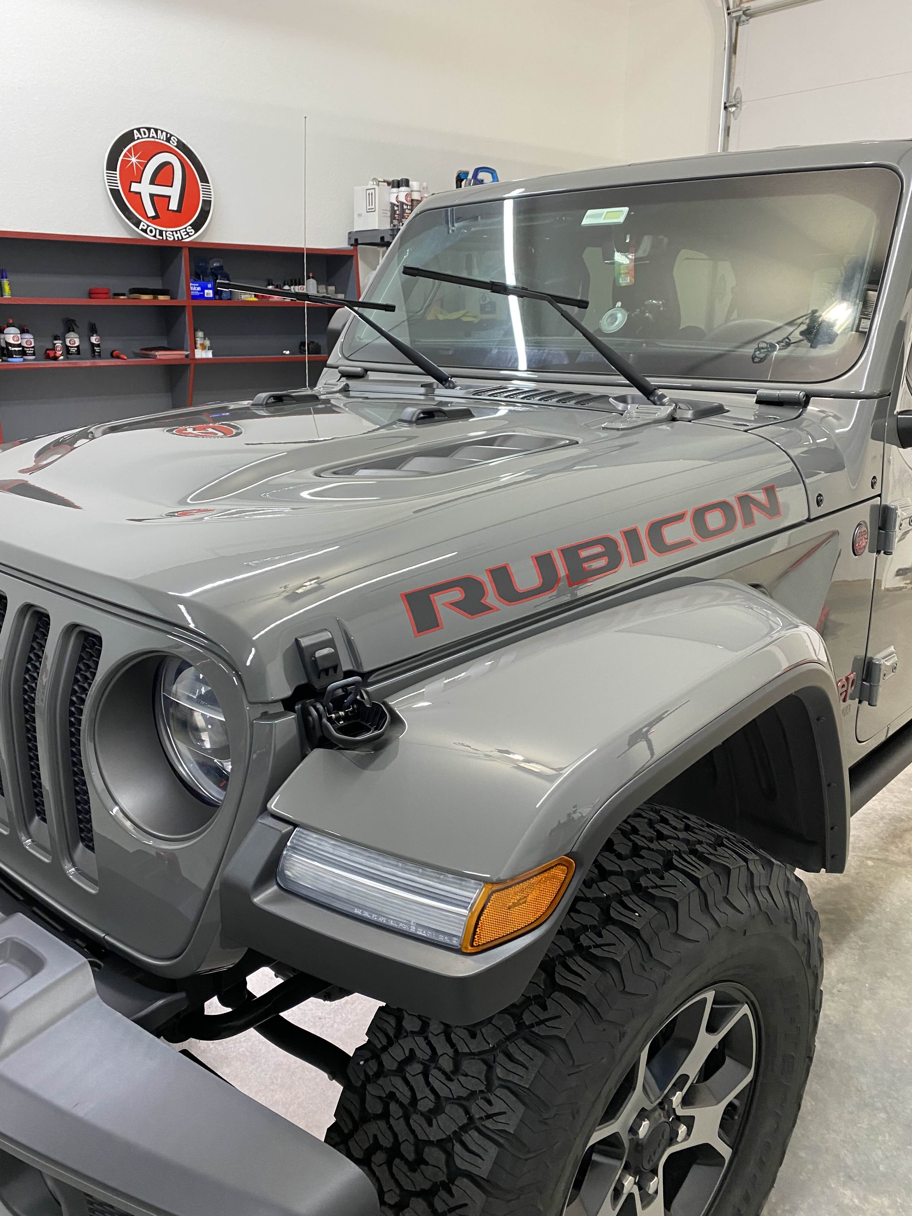 Grey Jeep Rubicon with soft top in professional workshop