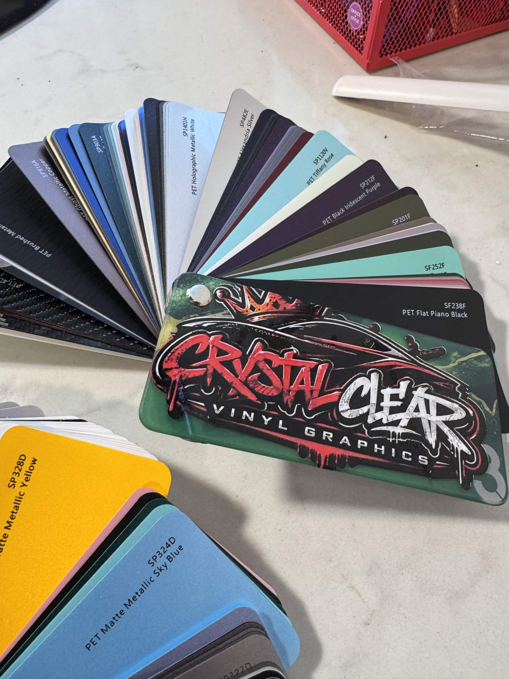 Crystal Clear Vinyl Graphics branded vinyl color swatch fan showing dozens of colors